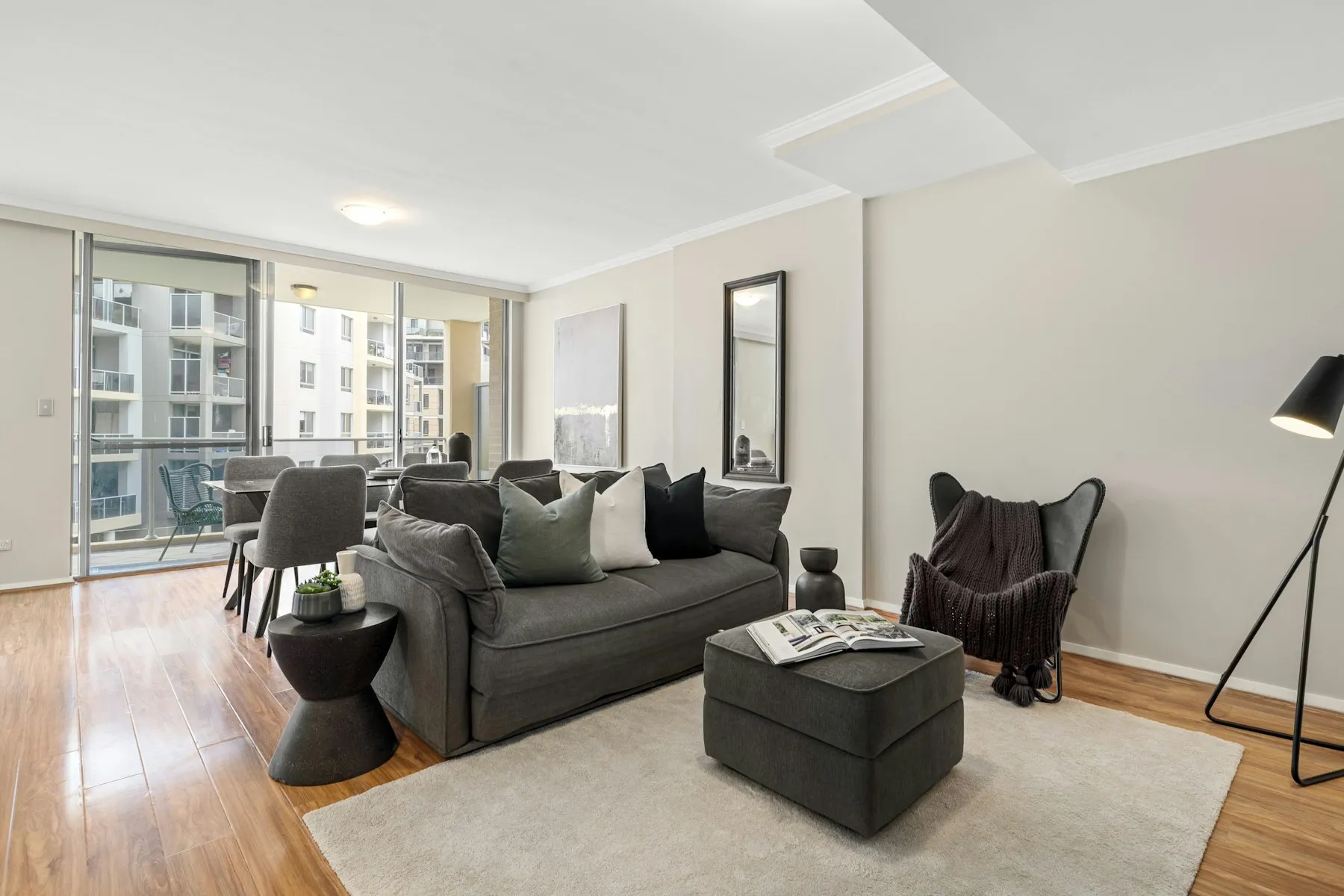 The living room, with a grey sofa, a footstool and a floor lamp