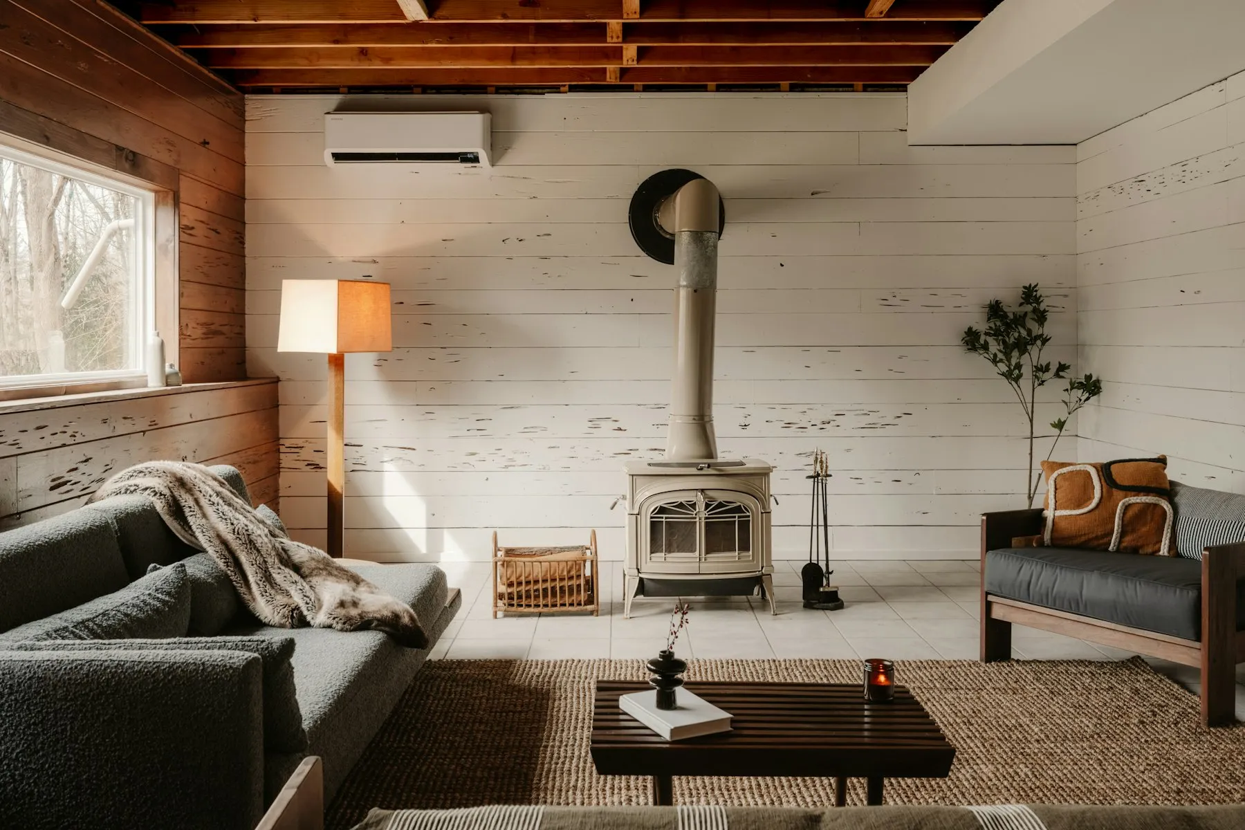 The sitting room, with a wood-burning stove, white panelled walls and a leather armchair