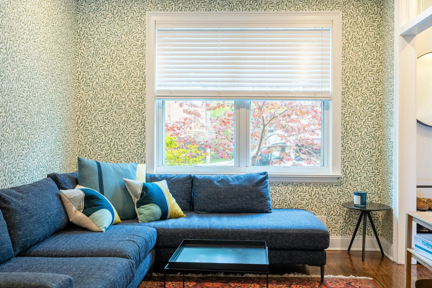 The sitting room, with a blue corner sofa and a large window