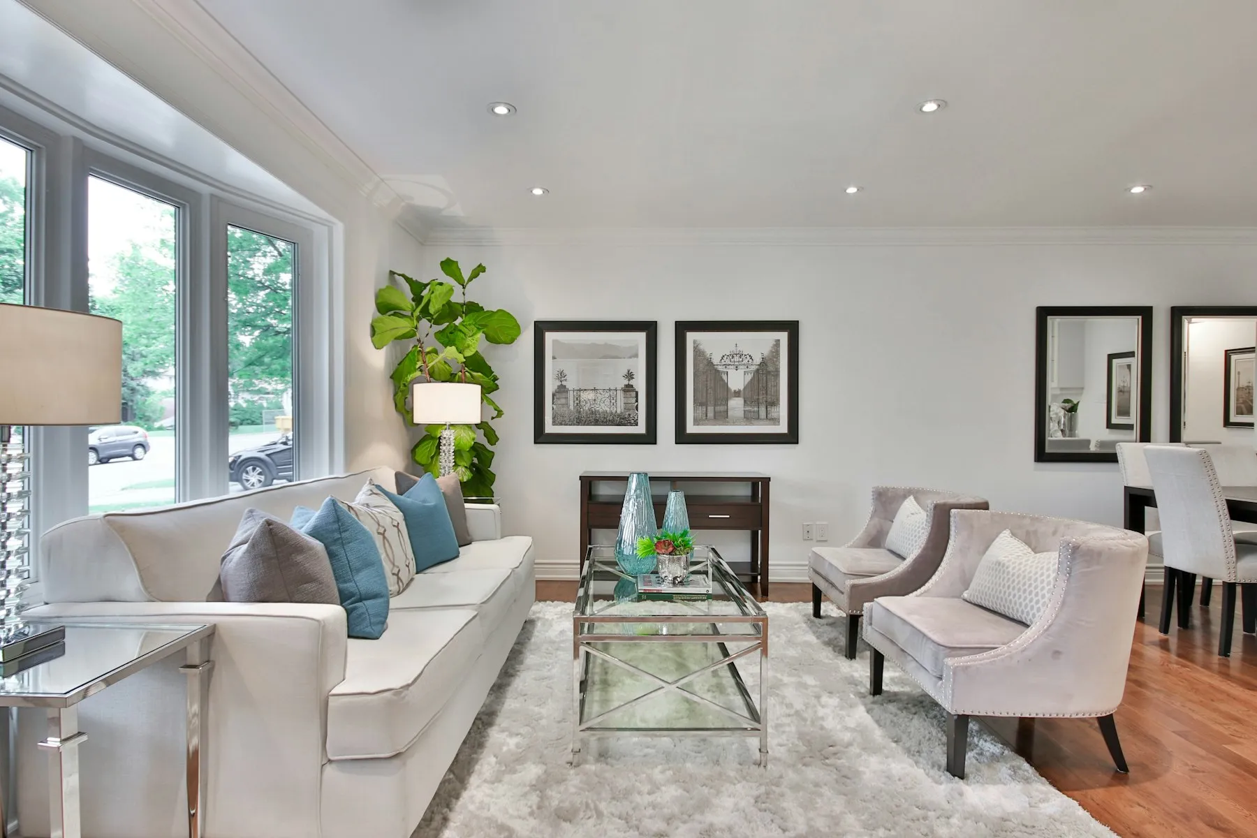 The double reception room, with white sofas, two armchairs and framed prints