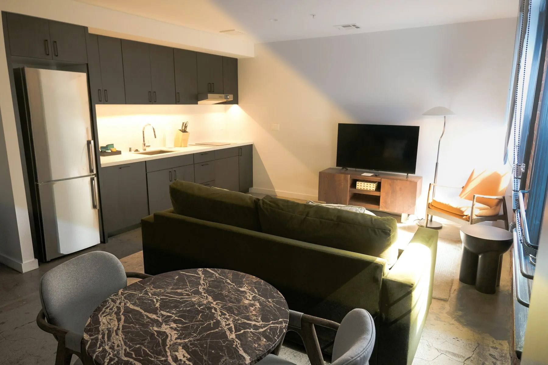 The open-plan living space, with the kitchen along one wall and a dining table in front