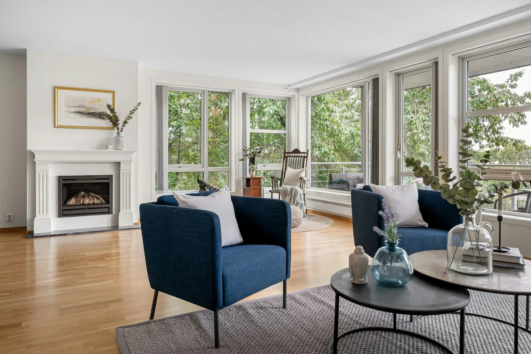 The sitting area, with two blue armchairs and windows onto the trees