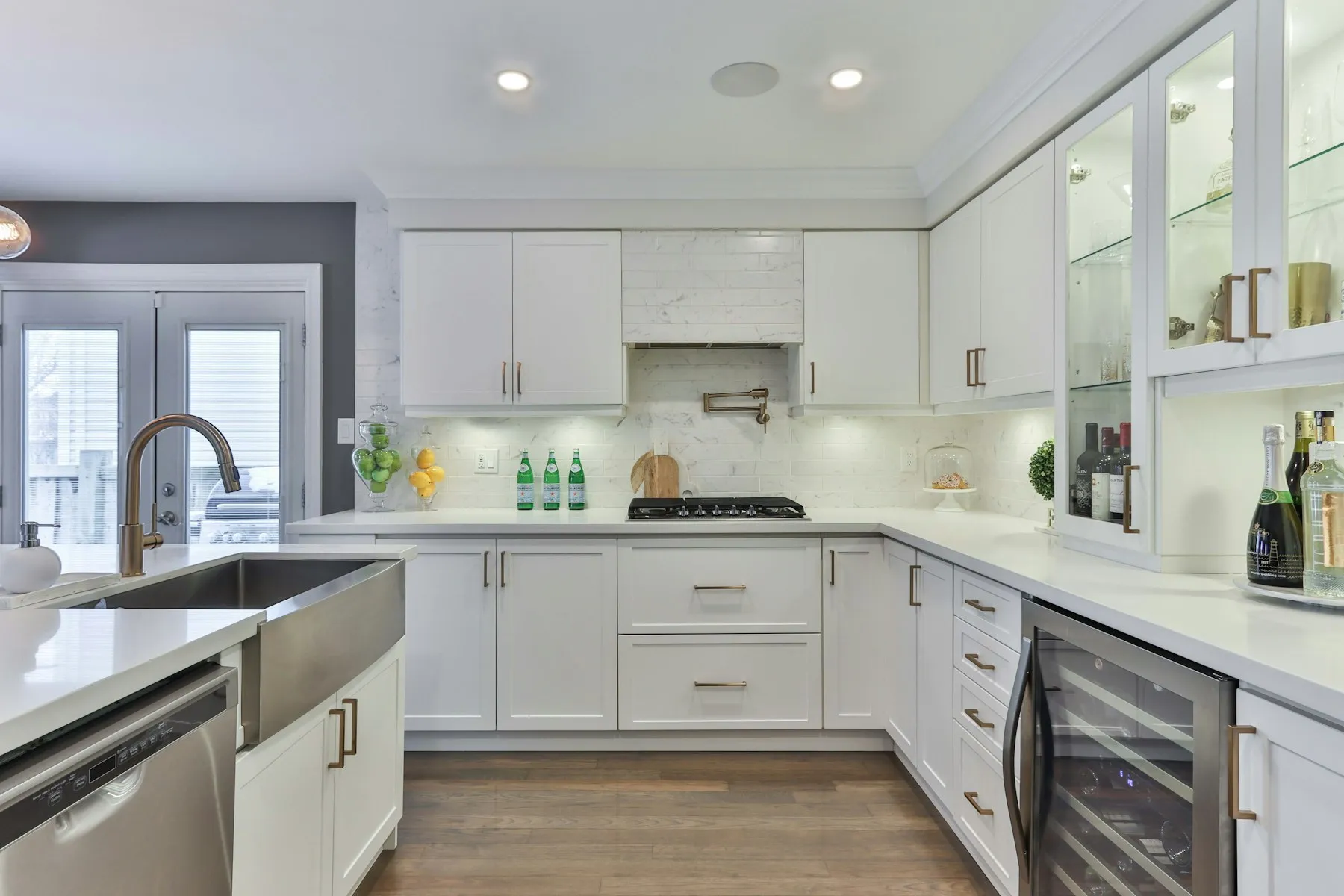The kitchen, with white shaker cabinets, a farmhouse sink and French doors