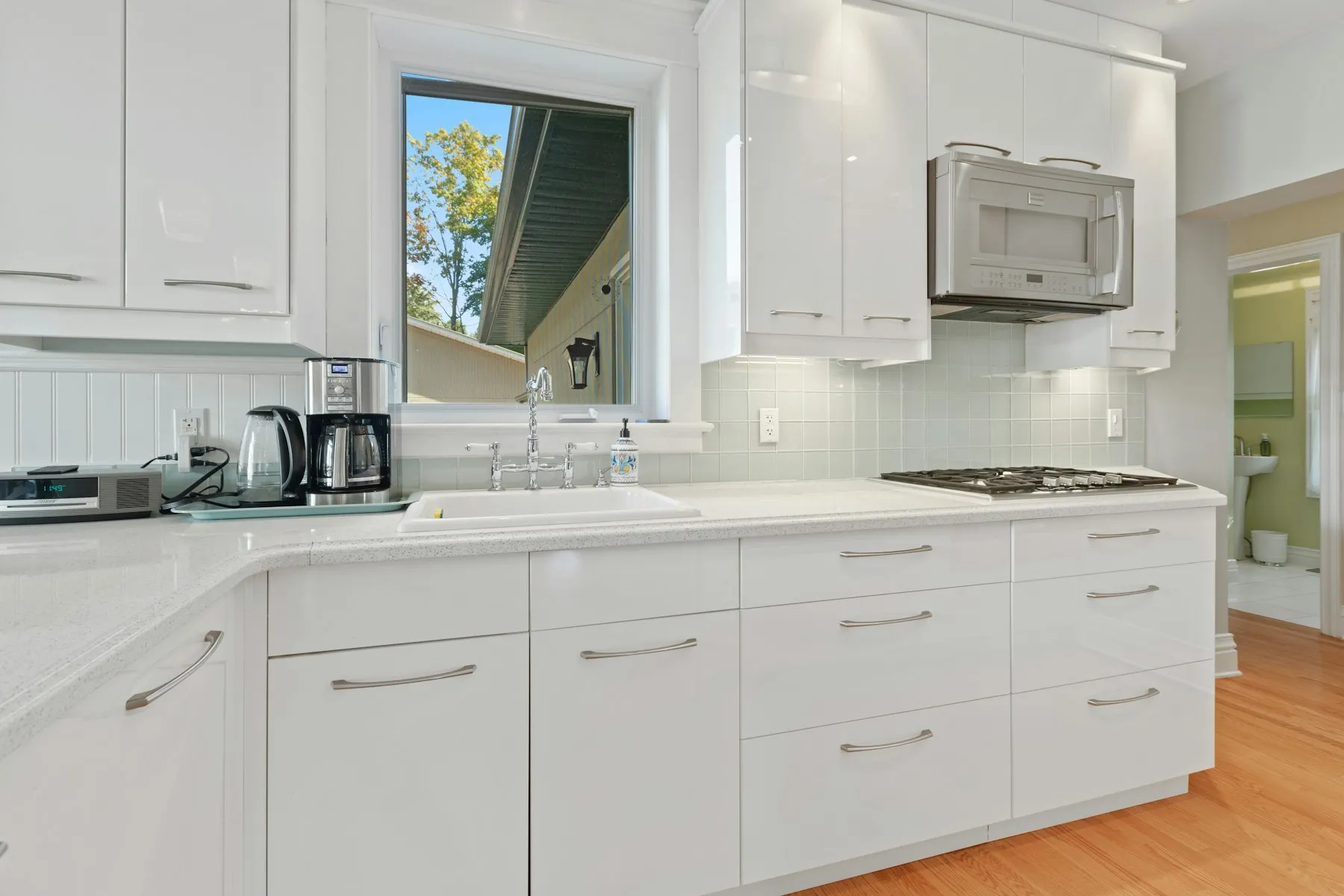 The kitchen, with white cabinets and a window over the sink