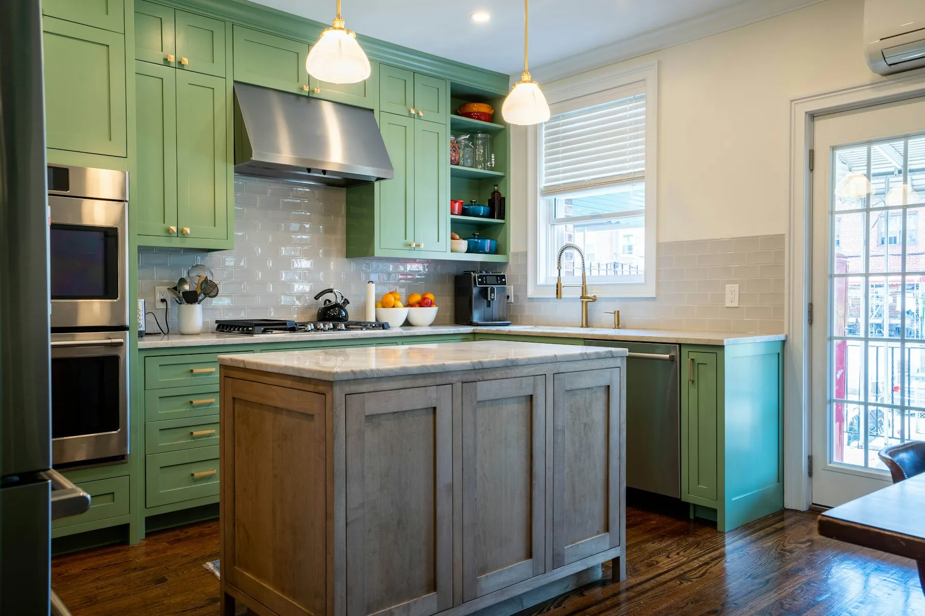 The kitchen, with green cabinets, a timber island and a range cooker