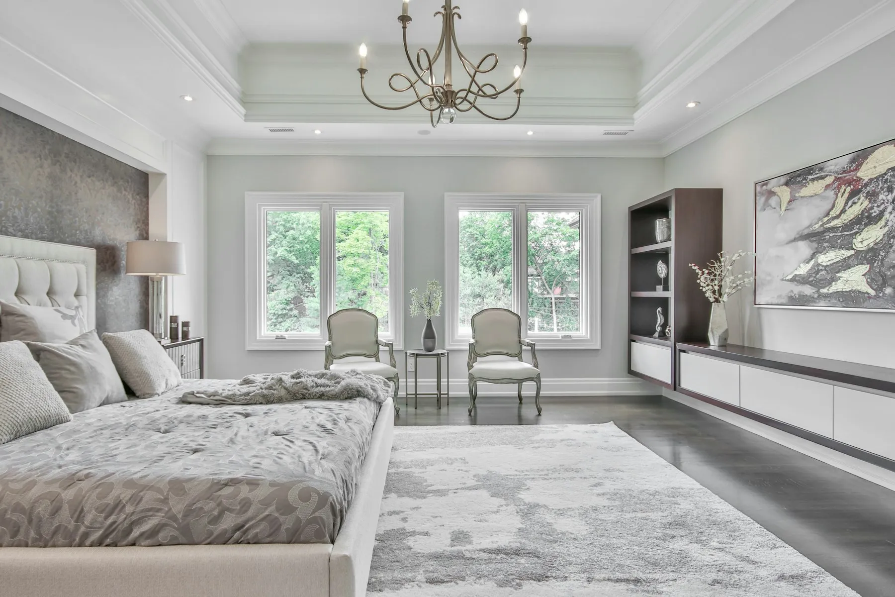 The principal bedroom, with a chandelier and windows on three sides