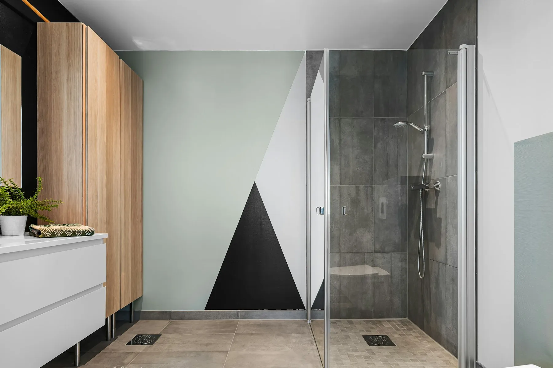 The shower room, with a black and white geometric wall and a glass screen