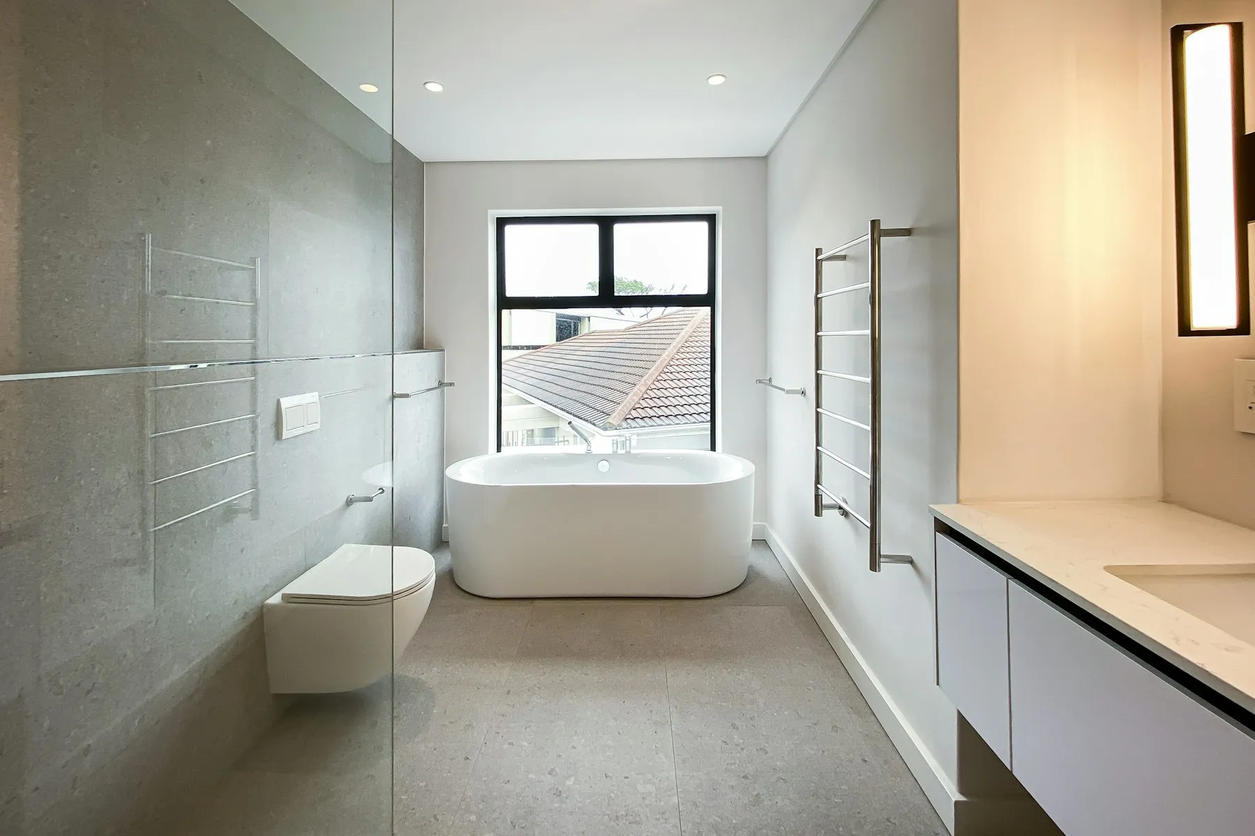 The bathroom, with a freestanding bath and grey stone tiles