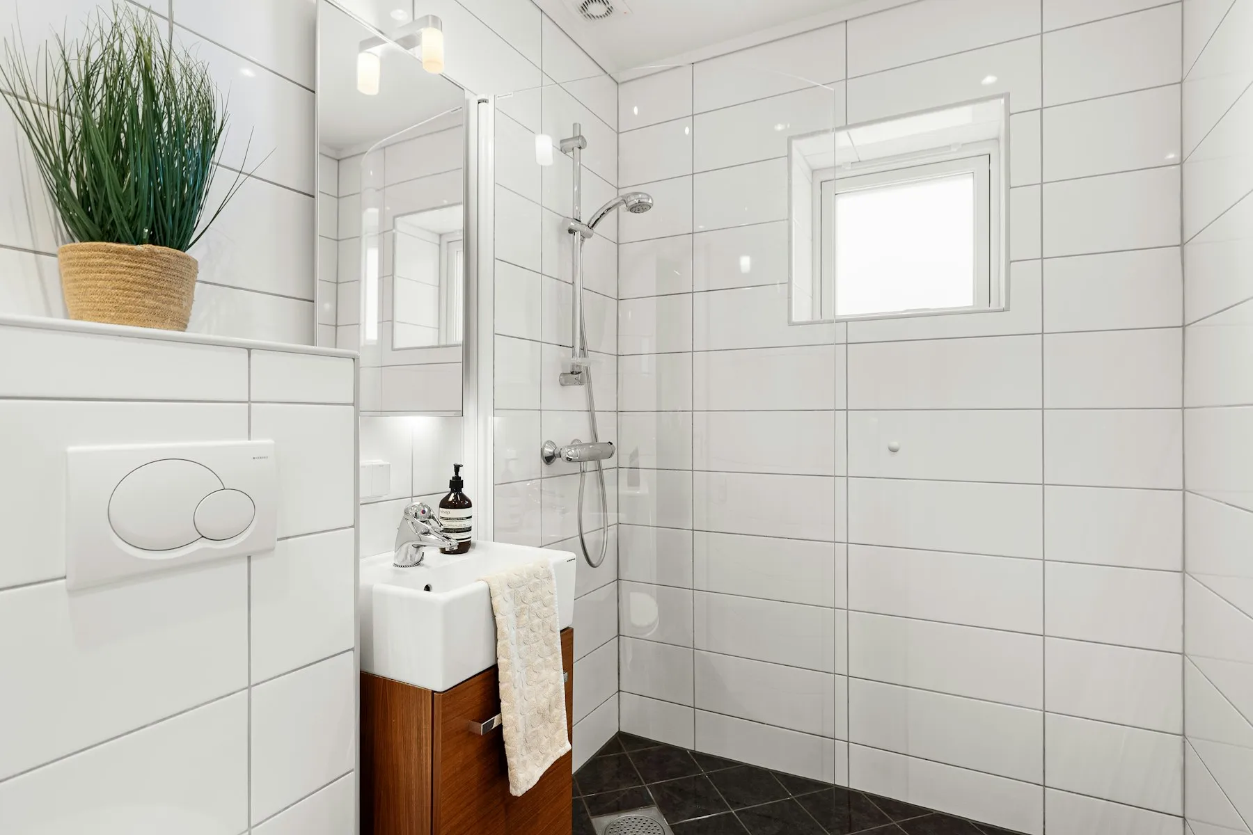 The bathroom, with white tiles and a walk-in shower