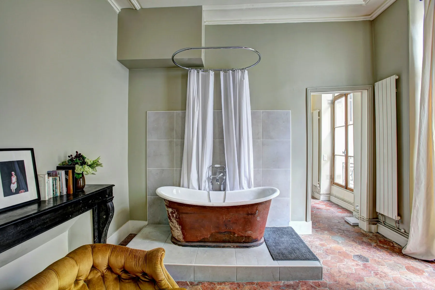 The bathroom, with a copper roll-top bath under a circular shower rail