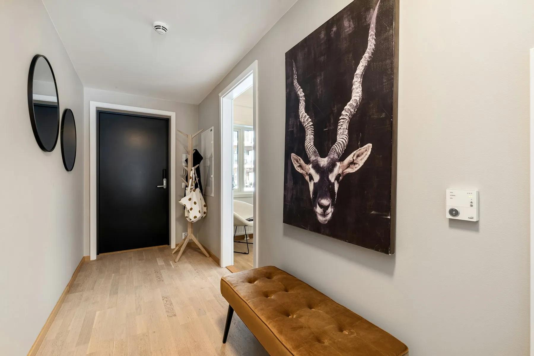 The entrance hall, with a leather bench and a framed print