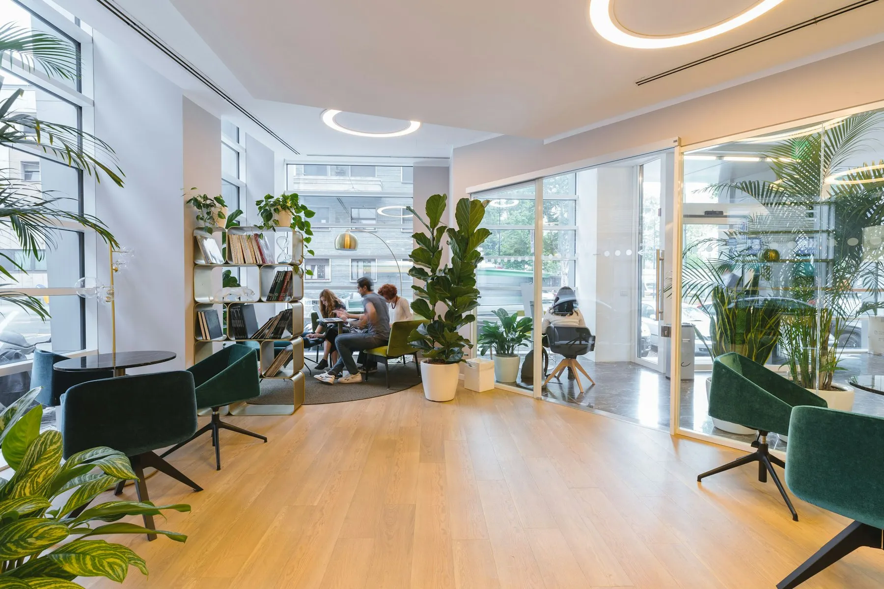 The open-plan Residenza office, with oak floors, glass partitions and green armchairs
